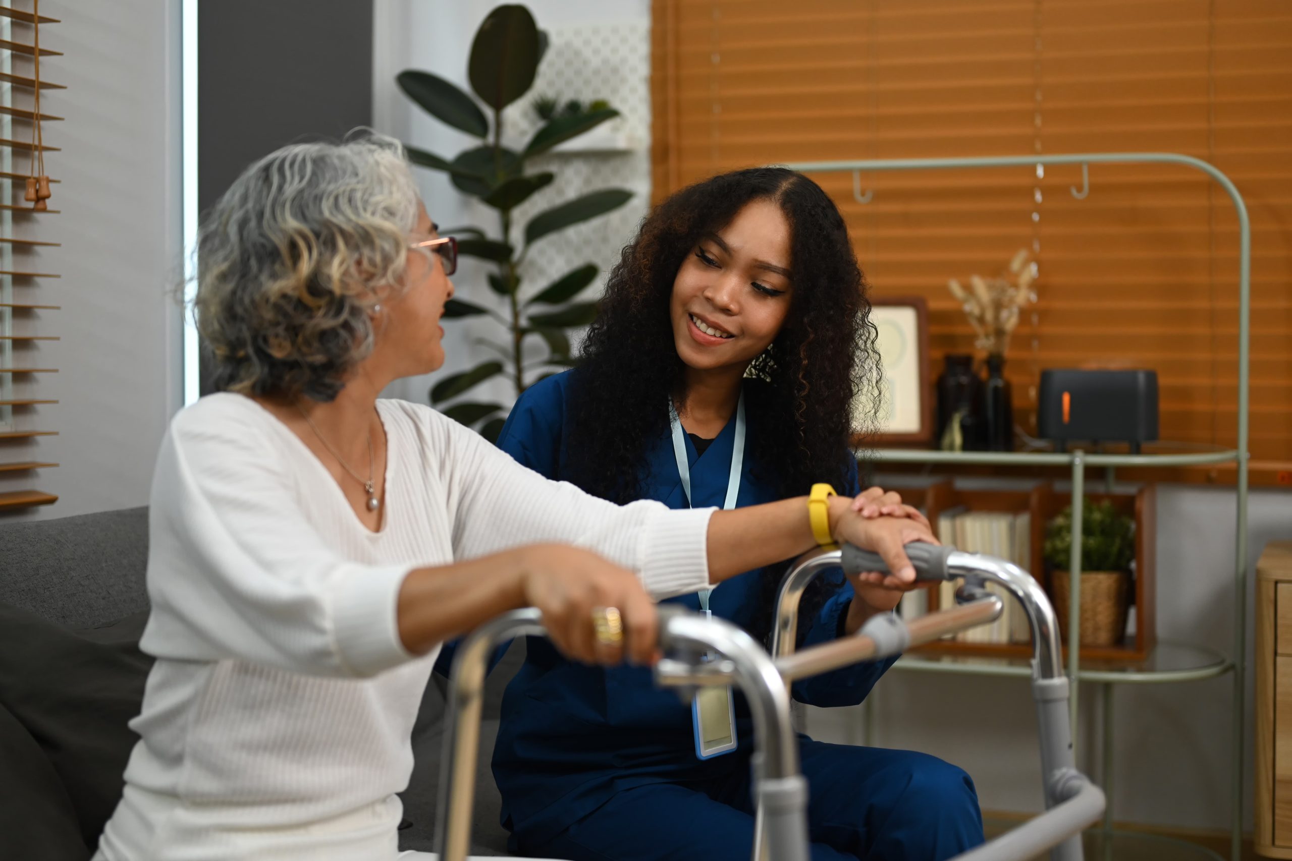 friendly-nurse-supporting-helping-elderly-woman-with-walking-frame-home-home-health-care-service-concept (1)